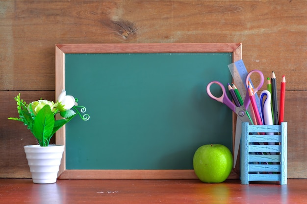 Koncepcja „Powrót do szkoły” z jabłkiem na stole przed tablicą