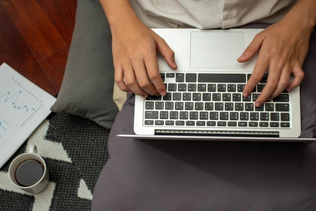 Koncepcja pracy zdalnej Mężczyzna freelancer używa laptopa do pisania danych biznesowych i pracy w salonie