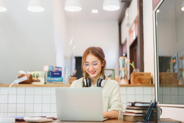 Koncepcja pracy zdalnej Przedsiębiorca kobieta wpisuje dane i pracuje na laptopie w przestrzeni coworkingowej