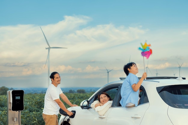 Koncepcja progresywnej szczęśliwej rodziny na farmie wiatrowej z pojazdem elektrycznym