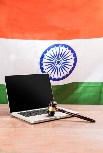 Koncepcja Przedstawiająca Prawo Indyjskie I Cybernetyczne Z Laptopem, Drewnianym Młotkiem Lub Młotkiem I Trójkolorową Flagą W Tle