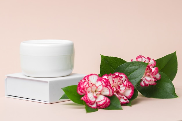 Koncepcja przemysłu kosmetycznego Biały słoik krem kosmetyczny z kwiatami