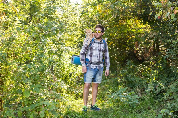 Koncepcja przygód, letniej turystyki i przyrody - turysta przyjeżdżający na kemping ze swoim kotem.