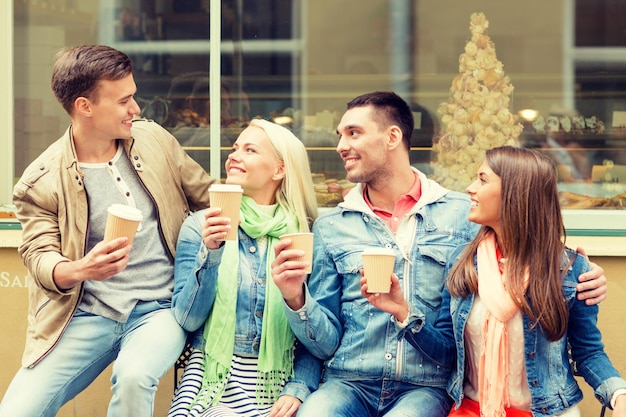 koncepcja przyjaźni, podróży, napojów i wakacji - grupa uśmiechniętych przyjaciół z kawą na wynos