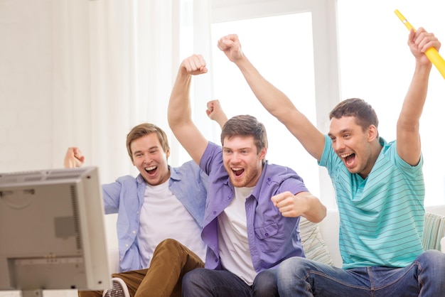 koncepcja przyjaźni, sportu i rozrywki - szczęśliwi przyjaciele płci męskiej z vuvuzela oglądający sport w telewizji