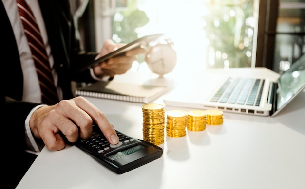 Koncepcja rachunkowości biznesowej Biznesmen korzystający z kalkulatora z budżetem na laptop komputerowy i papierem pożyczkowym w biurze
