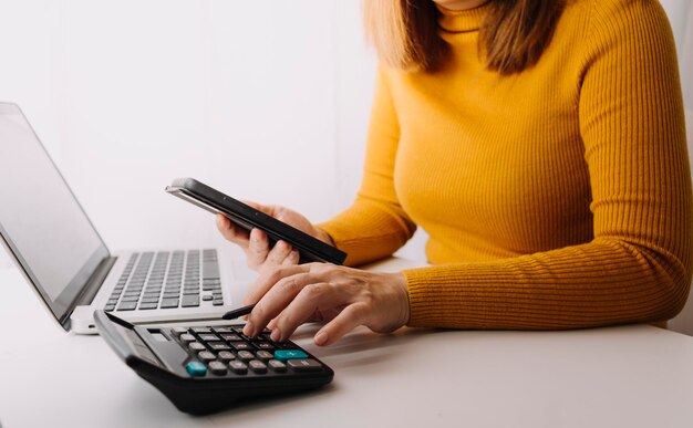 Koncepcja rachunkowości biznesowej Biznesmen korzystający z kalkulatora z budżetem na laptop komputerowy i papierem pożyczkowym w biurze