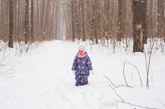 Koncepcja rodziny, dzieci i przyrody - piękne małe dziecko dziewczynka bawić się w winter park