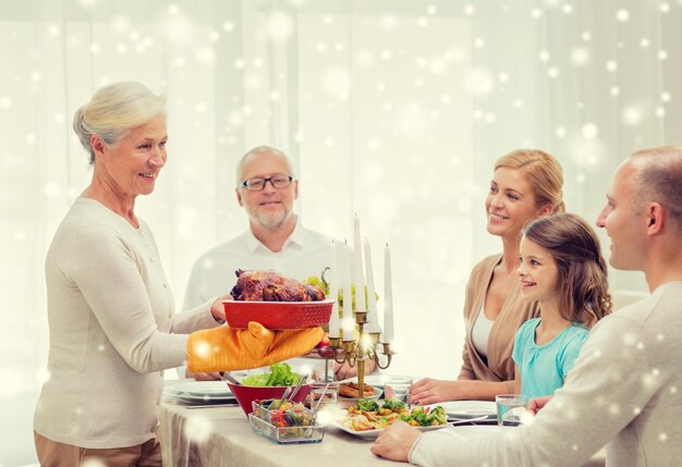 koncepcja rodziny, wakacji, pokolenia, świąt i ludzi - uśmiechnięta rodzina jedząca obiad w domu