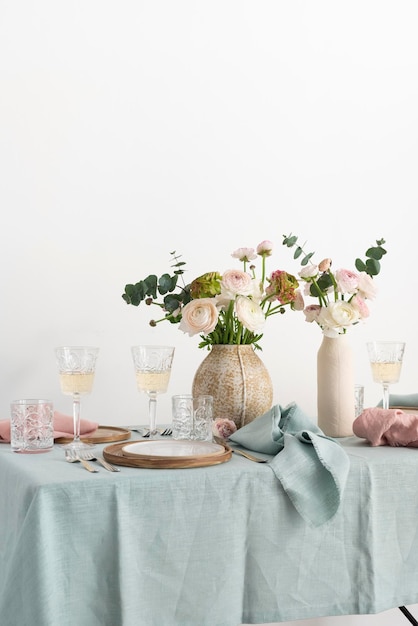 Koncepcja romantycznego stołu wielkanocnego z kwiatami i jasnozielonym obrusem selektywnej ostrości obrazu
