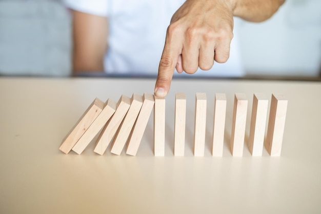 Zdjęcie koncepcja rozwiązania z ręcznym zatrzymaniem drewnianych bloków przed upadkiem w linii domino