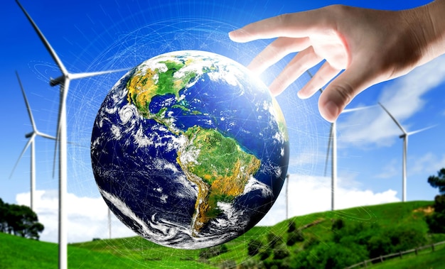 Koncepcja rozwoju zrównoważonego rozwoju poprzez energię alternatywną. Ręka człowieka dba o planetę Ziemię z przyjazną dla środowiska farmą turbin wiatrowych i zieloną energią odnawialną w tle.