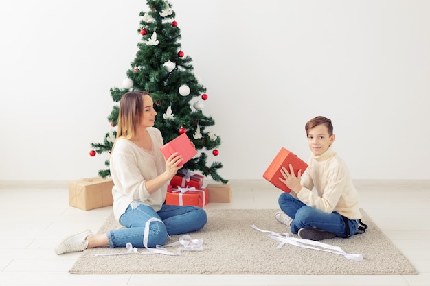 Koncepcja samotnego rodzica i święta - Portret matki i dziecka świętujących Boże Narodzenie w domu w Wigilię Bożego Narodzenia