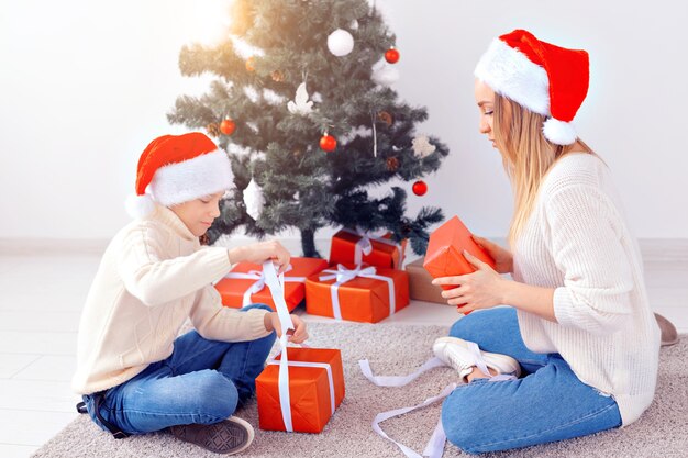 Koncepcja samotnego rodzica i święta - Portret matki i syna świętujących Boże Narodzenie w domu w Wigilię Bożego Narodzenia
