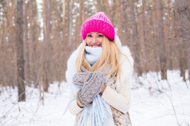 Koncepcja sezonu i ludzi - atrakcyjna blond kobieta ubrana w biały fartuch i różowy kapelusz stojący w lesie