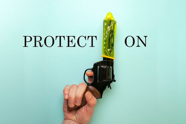 Koncepcja silnej prezerwatywy, żółtego środka antykoncepcyjnego, ubranego na lufie pistoletu