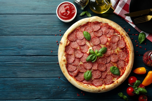 Koncepcja smacznego jedzenia z pizzą salami na drewnianym stole