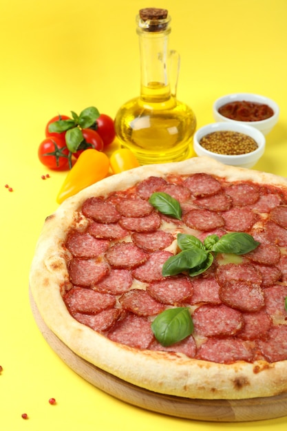 Koncepcja smacznego jedzenia z pizzą salami na żółtym tle
