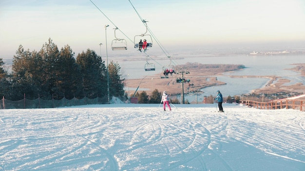 Koncepcja snowboardowa kolejka linowa dojeżdżająca do stacji ludzie jeżdżący na snowboardzie