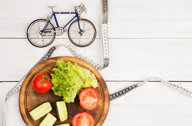 Koncepcja sportu i diety model roweru świeże warzywa i centymetrowa taśma