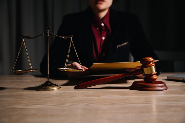 Koncepcja sprawiedliwości i prawaSędzia w sali sądowej z młotkiem pracującym z komputerem i dokującą klawiaturą okularów na stole w porannym świetle