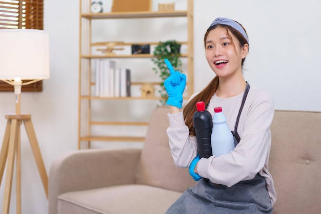 Koncepcja sprzątania Pokojówka robi kciuki w górę i trzyma środek czyszczący do sprzątania domu
