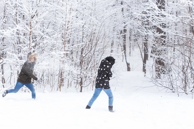 Koncepcja stylu życia, sezonu i wypoczynku - zabawna para gra w snowball w winter park.