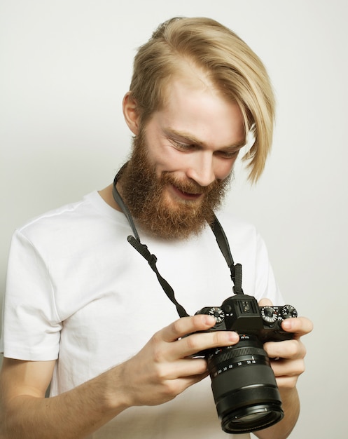Koncepcja Stylu życia, Technologii I Ludzi: Profesjonalny Fotograf. Portret Pewnie Młody Człowiek W Koszuli Trzymając Aparat Nad Białą Przestrzenią