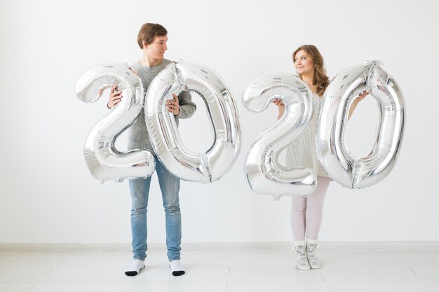 Koncepcja świąt, świąt I Imprez - Szczęśliwa Kochająca Zabawna Para Trzyma Srebrne Balony 2020. Obchody Nowego Roku