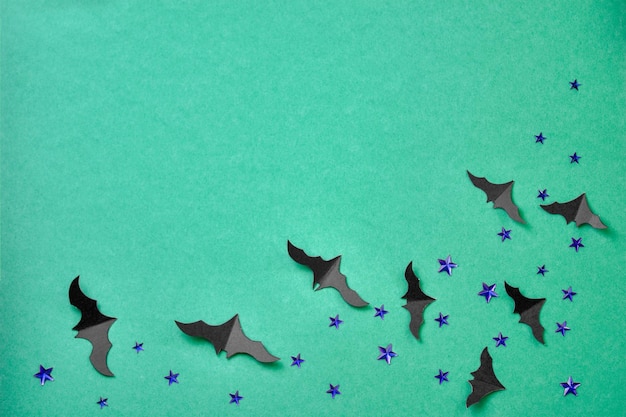 Zdjęcie koncepcja świątecznych nietoperzy papierowych na zielonym tle