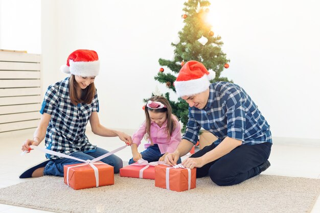 Koncepcja święta i prezenty - portret szczęśliwej rodziny otwieranie prezentów w czasie świąt Bożego Narodzenia.