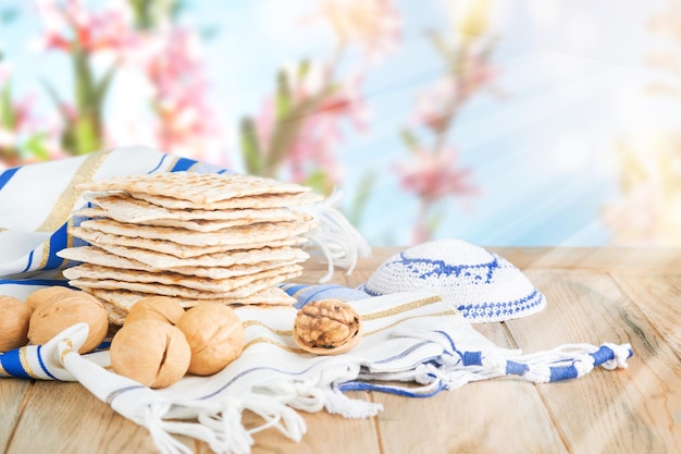 Koncepcja świętowania Pesach Matzah czerwony koszer i orzech włoski na drewnianym vintage stoliku stołu przed wiosną kwitnące drzewo ogród i kwiaty krajobraz z promieniami słońca z kopiowania przestrzeni Mock up