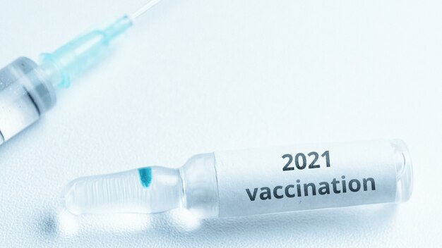 Koncepcja szczepionki Covid w 2021 roku. Ampułka z lekiem i strzykawką.