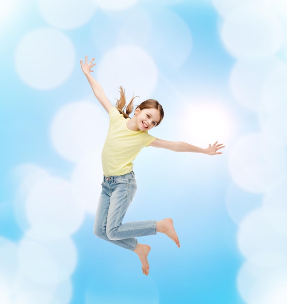 koncepcja szczęścia, aktywności i dziecka - uśmiechnięta skacząca dziewczynka