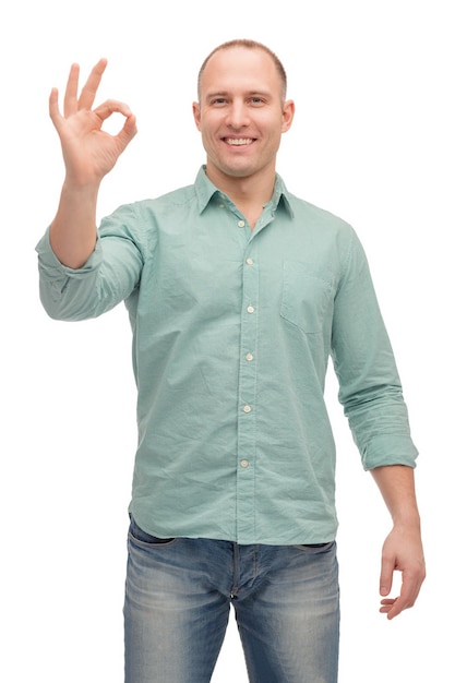 koncepcja szczęścia, gestu i ludzi - uśmiechnięty mężczyzna pokazujący znak ok