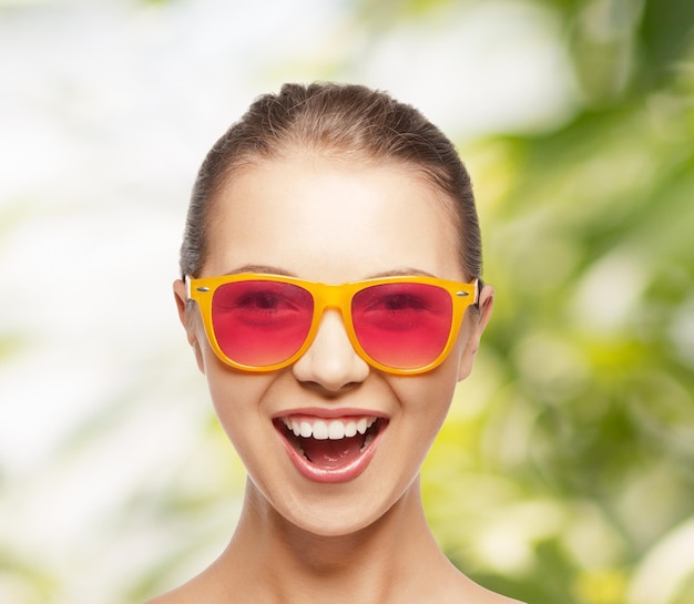 koncepcja szczęścia i ludzi - portret szczęśliwej nastolatki w różowych okularach przeciwsłonecznych