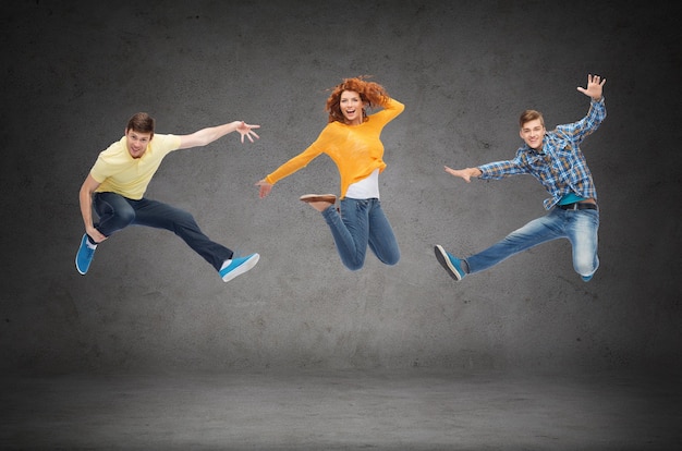Zdjęcie koncepcja szczęścia, wolności, przyjaźni, edukacji i ludzi - grupa uśmiechniętych nastolatków skaczących w powietrzu na zielonym tle tablicy