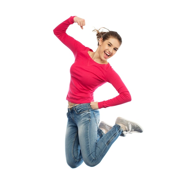 koncepcja szczęścia, wolności, władzy, ruchu i ludzi - uśmiechnięta młoda kobieta skacze w powietrzu z podniesionymi pięściami na białym tle