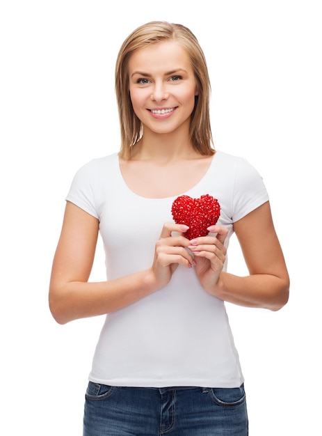 koncepcja szczęścia, zdrowia i miłości - uśmiechnięta kobieta w białej koszulce z sercem