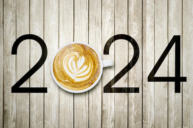 Koncepcja szczęśliwego nowego roku Widok z góry sztuki kawy latte z numerem 2024 na drewnianym stole