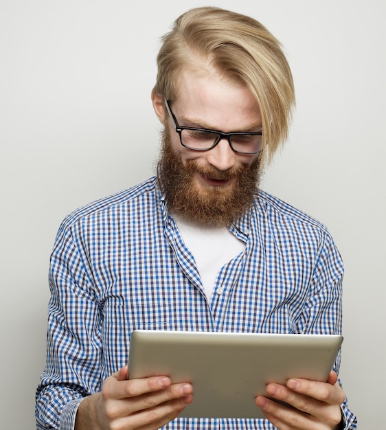 Zdjęcie koncepcja technologii, edukacji i stylu życia: młody człowiek za pomocą komputera typu tablet - na szarym tle