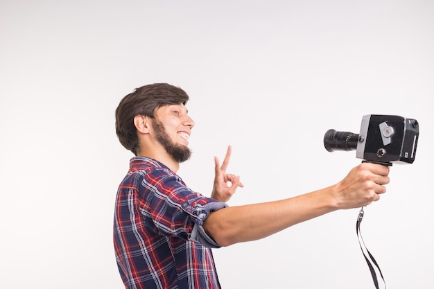 Koncepcja technologii, fotografii i ludzi - zabawny mężczyzna w koszuli w kratę, biorąc selfie nad białym