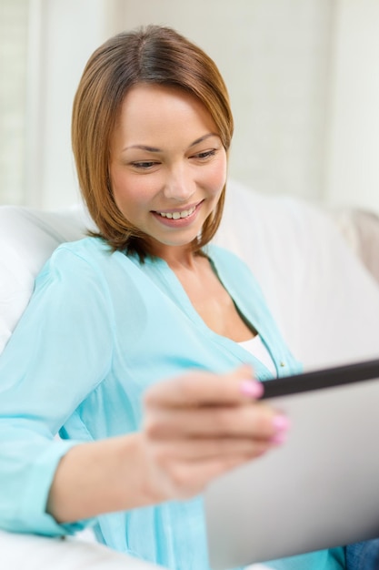 koncepcja technologii, internetu i domu - kobieta z komputerem typu tablet w domu
