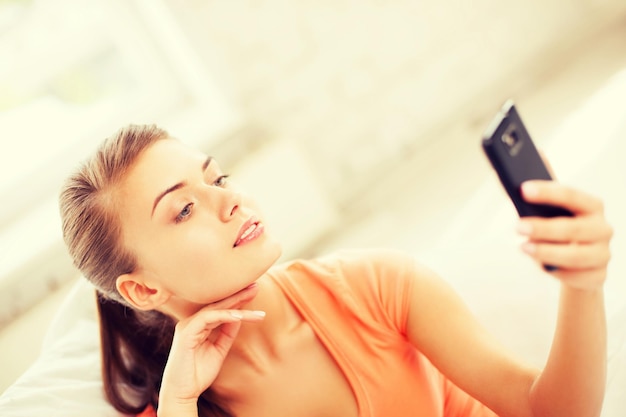 koncepcja technologii - kobieta robi autoportret za pomocą smartfona
