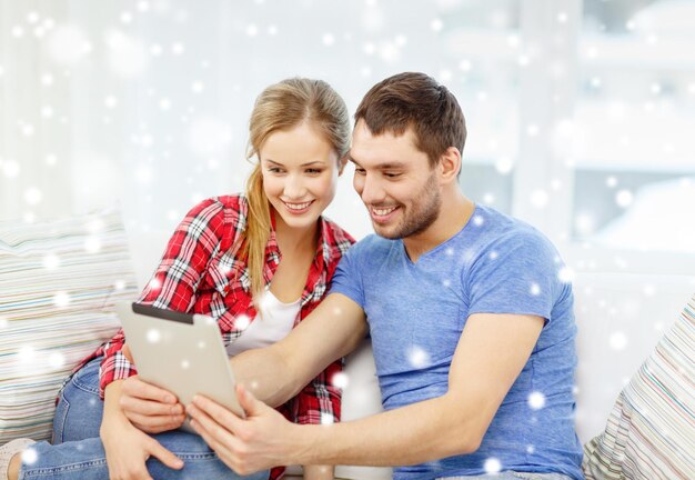 koncepcja technologii, ludzi i relacji - uśmiechnięta para z laptopem siedzi na kanapie w domu