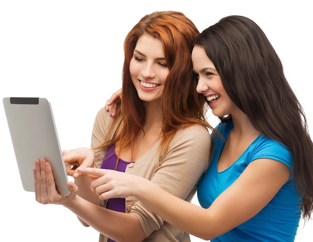 koncepcja technologii, przyjaźni i ludzi - dwóch uśmiechniętych nastolatków wskazujących palcem na ekran komputera typu tablet
