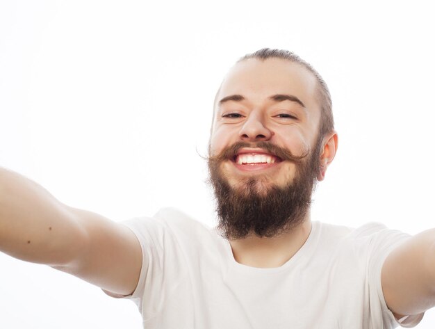 Koncepcja technologii: szczęśliwe selfie. Przystojny młody mężczyzna trzyma aparat i robi selfie i uśmiechnięty.