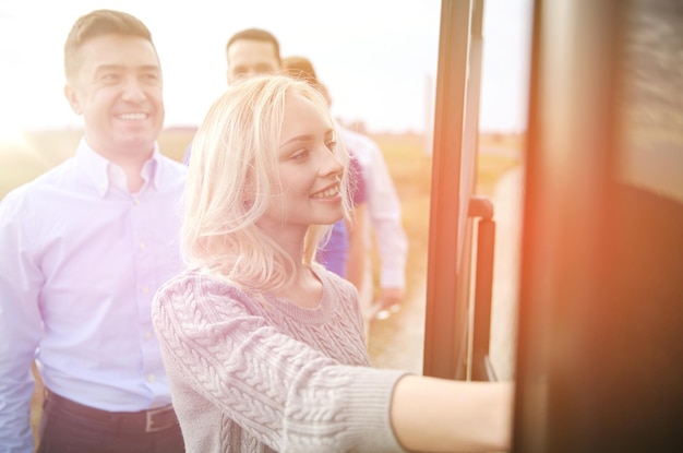 koncepcja transportu, turystyki, podróży i ludzi - grupa szczęśliwych pasażerów wsiadających do autobusu podróżnego