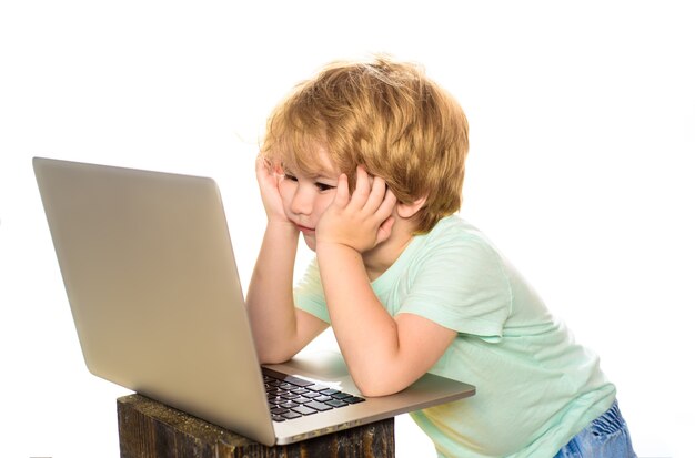 Koncepcja uczenia się mały chłopiec z laptopem lub notebookiem w domu praca domowa z internetu i społecznościowe