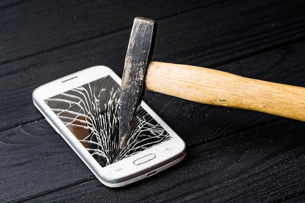 Koncepcja uszkodzonego smartfona Rozbity telefon młotkiem